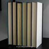 Black and blue hardcover real books staged and used as home décor. Book stack on a shelf.