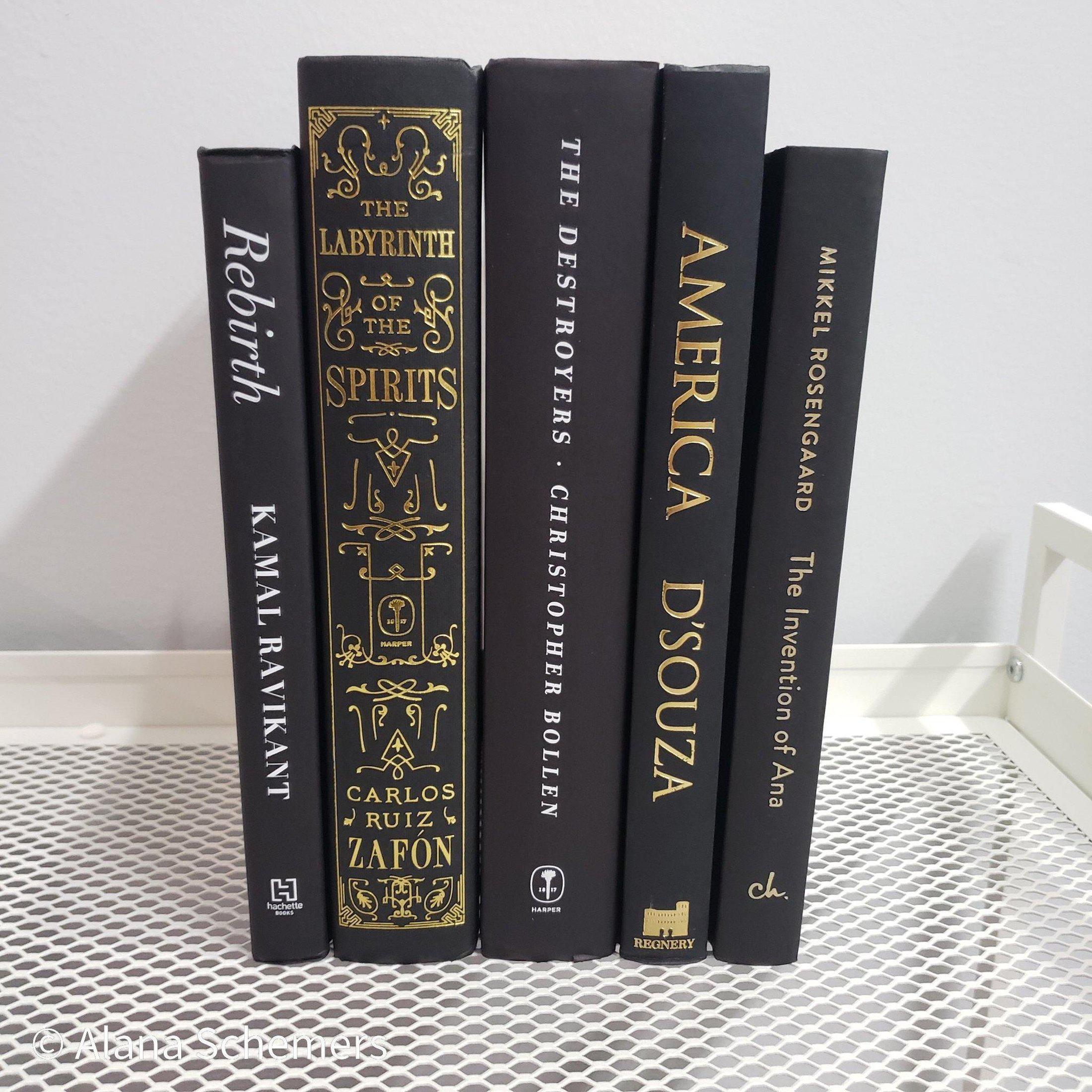 Stack of Black Books Gold & White Accent. Real hardcover books staged and used for decorating.