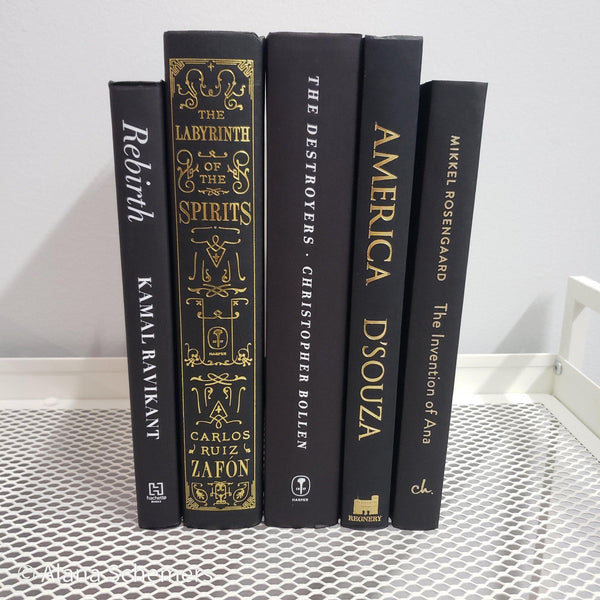 Stack of Black Books Gold & White Accent. Real hardcover books staged and used for decorating.
