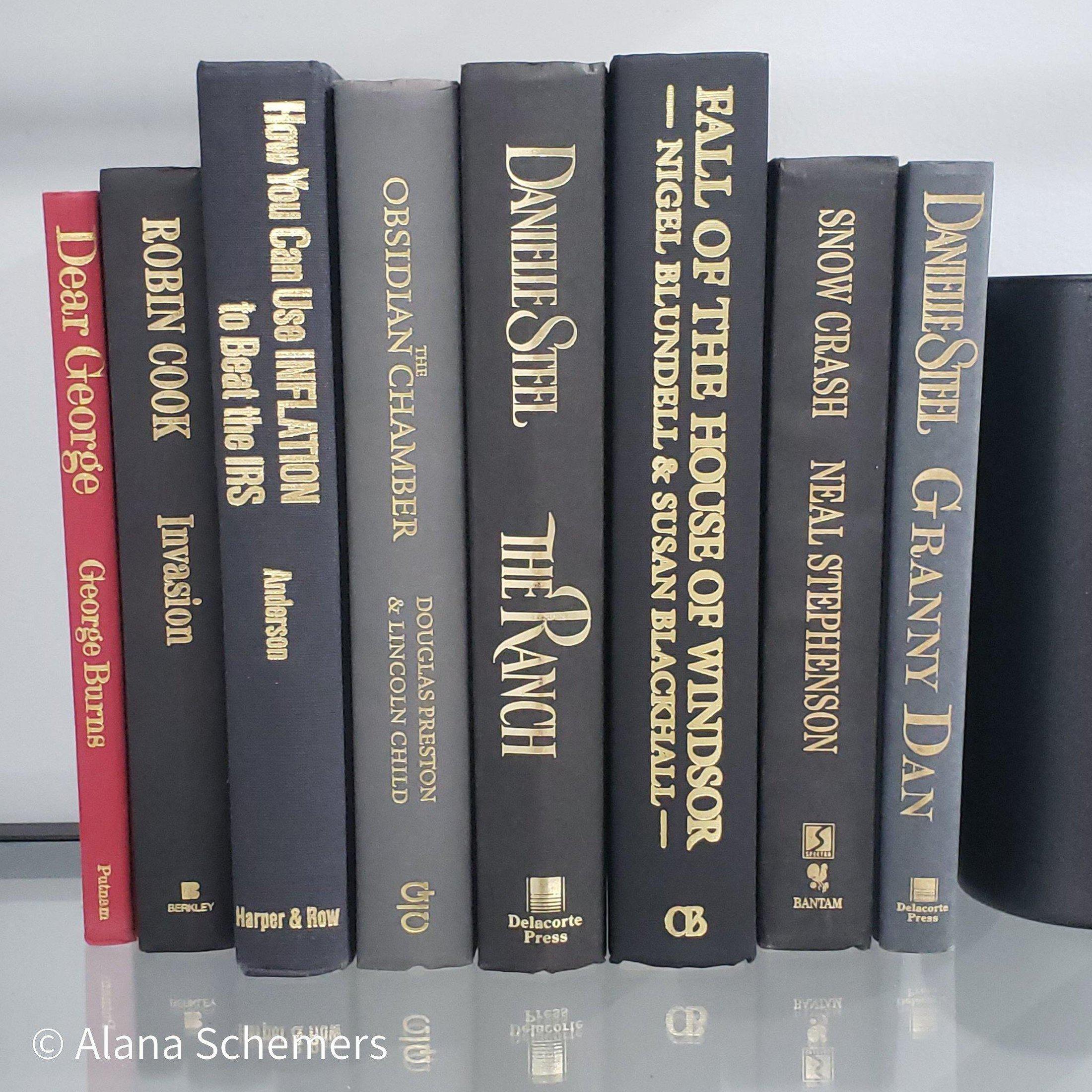 Book Stack Most Vintage & Bookend on glass shelf for display in home. Harcover books in black gray and red. Real books to read or decorate with. 
