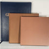 Stack of hardcover books in navy blue and neutral colors. Real books staged and used for decorating.
