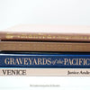 Stack of hardcover books in navy blue and neutral colors. Real books staged and used for decorating.