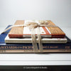 Stack of hardcover books in navy blue and neutral colors. Real books staged and used for decorating.