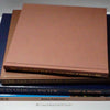 Stack of hardcover books in navy blue and neutral colors. Real books staged and used for decorating.