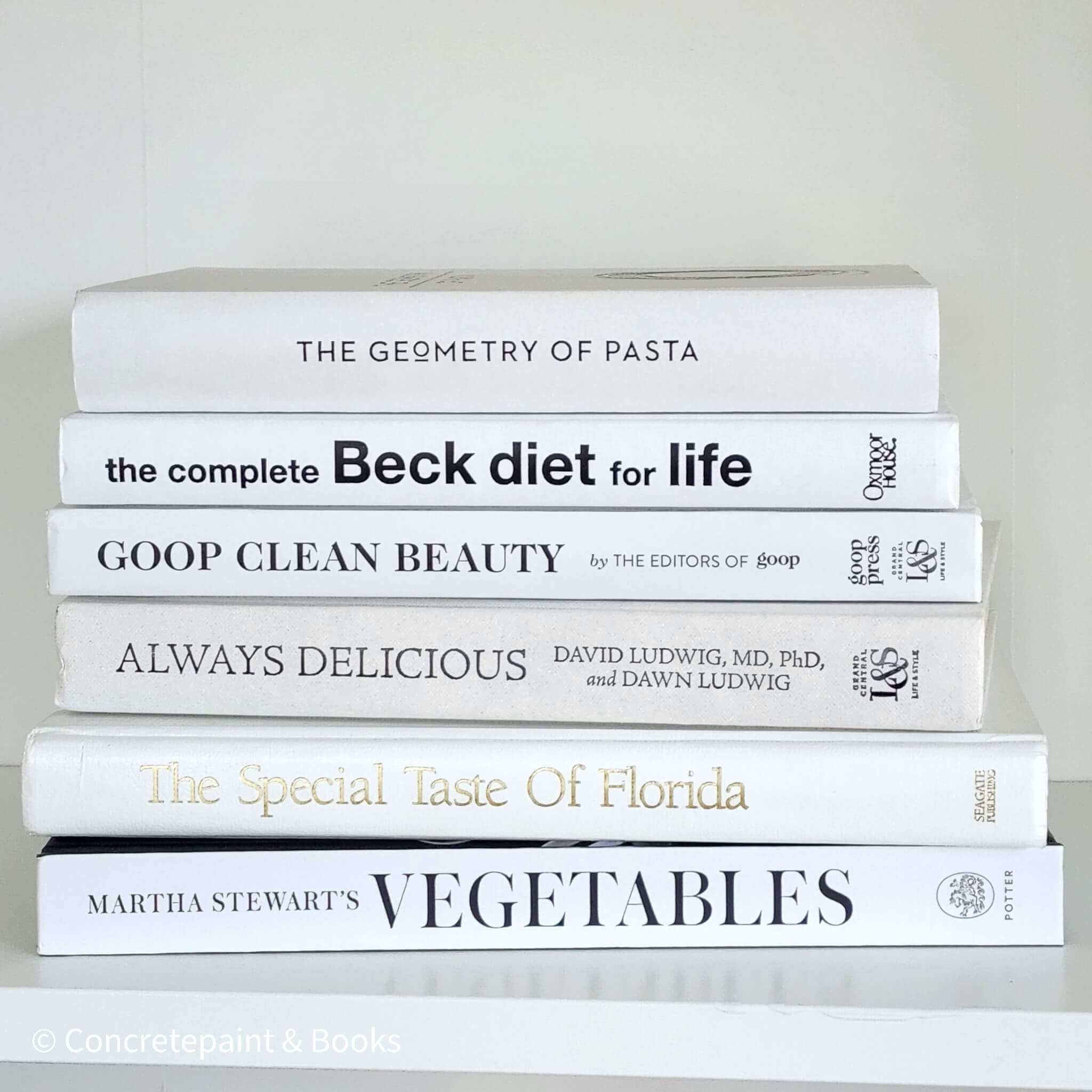 Stack of white decorative cookbooks for display.  Modern black and white kitchen decor.