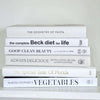 Stack of white decorative cookbooks for display.  Modern black and white kitchen decor.