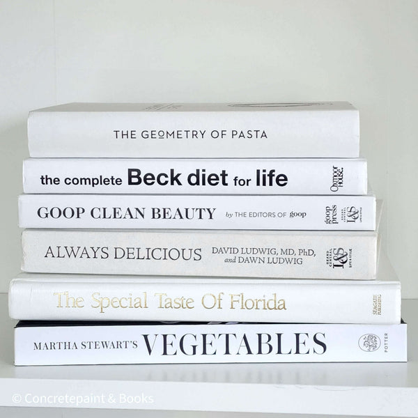 Stack of white decorative cookbooks for display.  Modern black and white kitchen decor.