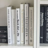 Stack of white decorative cookbooks for display. 