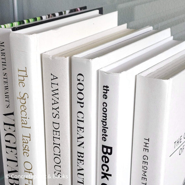 Stack of white decorative cookbooks for display. 