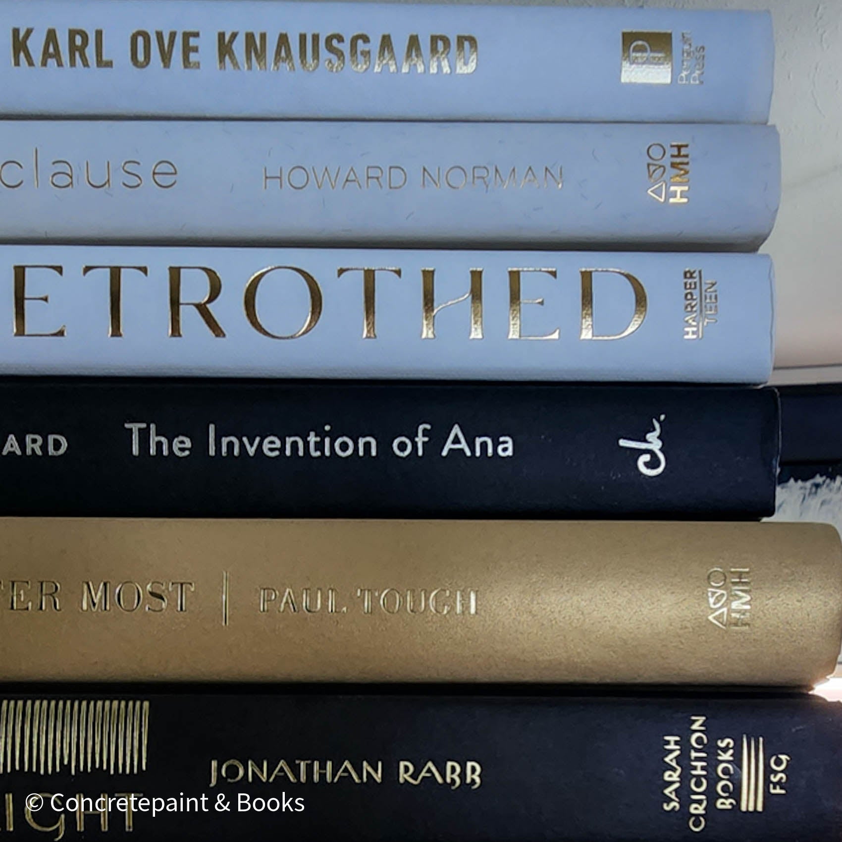 Stack of gold, black, and white book display. Real books used for modern and glam decorating. 