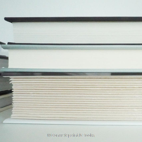Real books used as home décor. Stack of all black hardcover books including coffee table books, and novels.