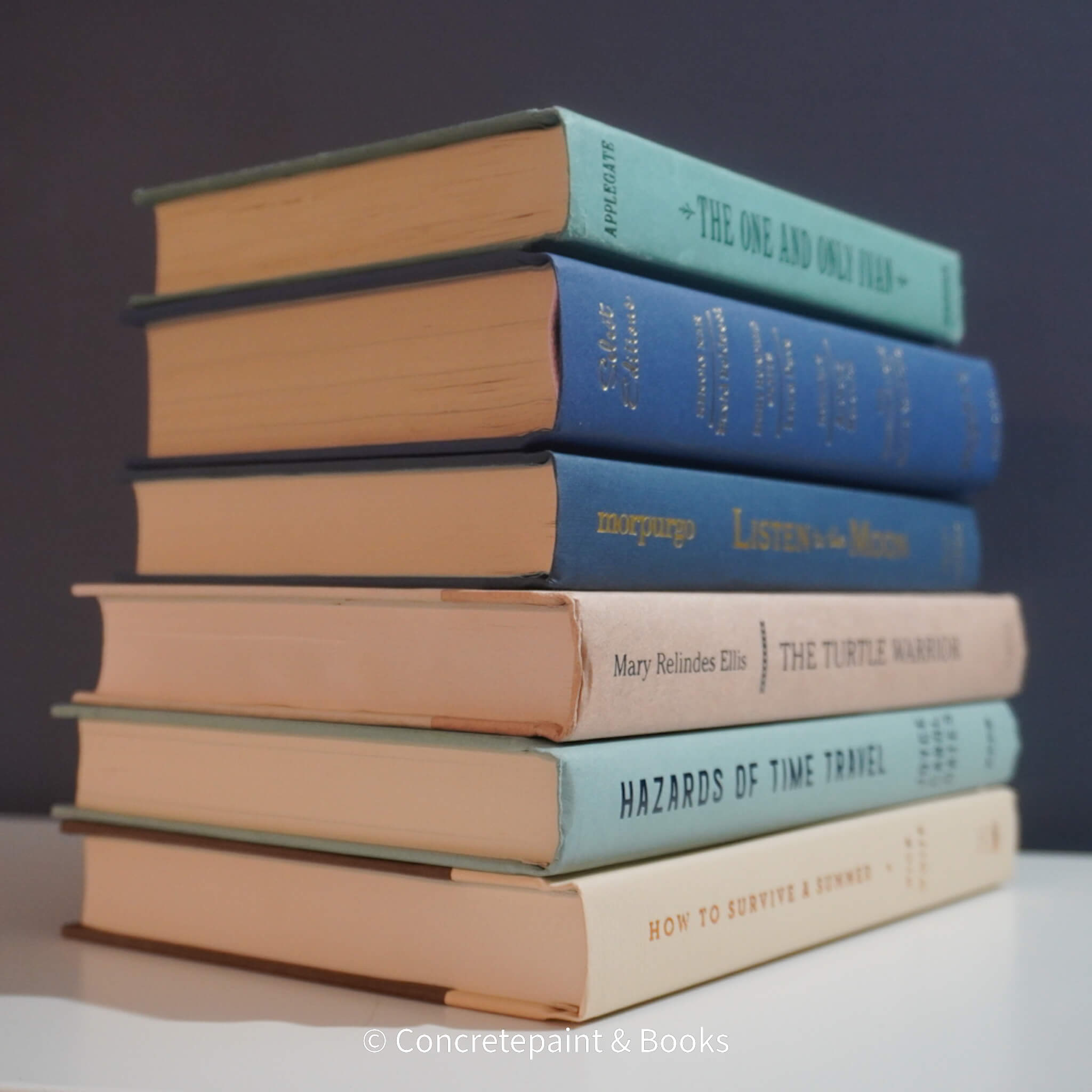 Neutral, mint, and navy color books used for decorating. Stack of real hardcover books for display. 