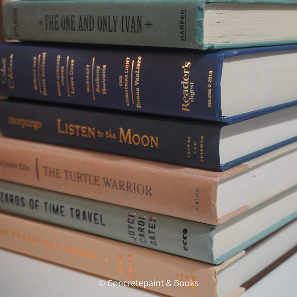 Neutral, mint, and navy color books used for decorating. Stack of real hardcover books for display. 