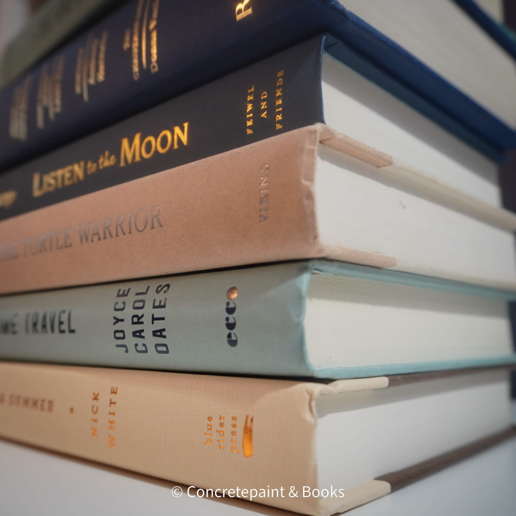 Neutral, mint, and navy color books used for decorating. Stack of real hardcover books for display. 