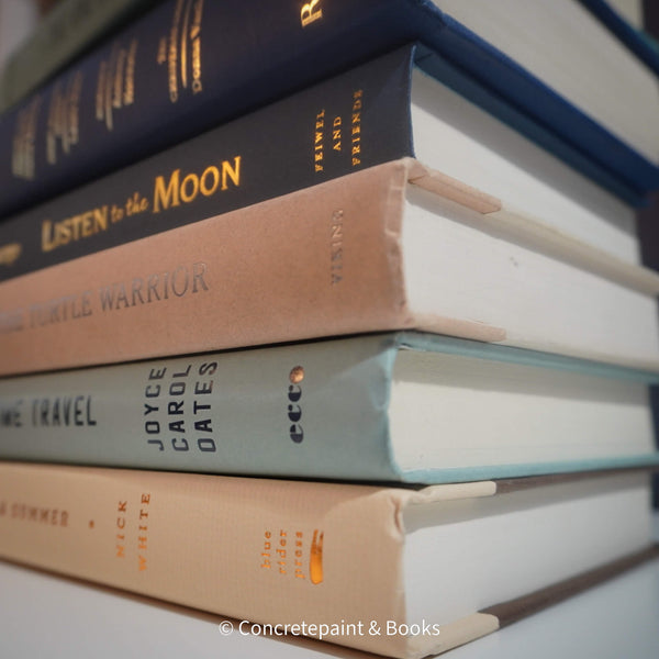 Neutral, mint, and navy color books used for decorating. Stack of real hardcover books for display. 