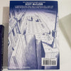 Stack of white and blue hardcover coffee table books. 