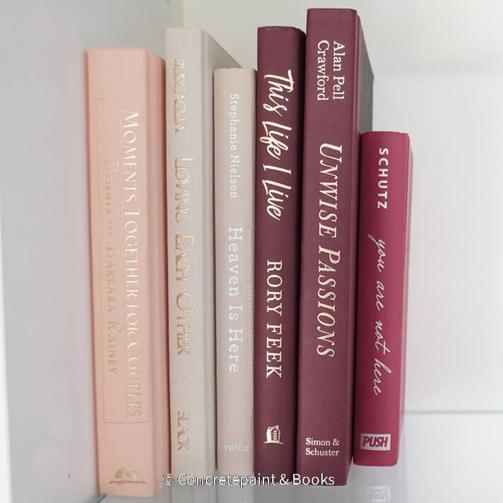 Stack of burgundy, blush, and neutral color books. Real hardcover books used for decorating.