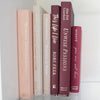 Stack of burgundy, blush, and neutral color books. Real hardcover books used for decorating.