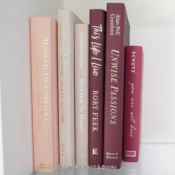 Stack of burgundy, blush, and neutral color books. Real hardcover books used for decorating.