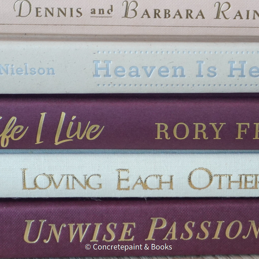 Stack of burgundy, blush, and neutral color books. Real hardcover books used for decorating.