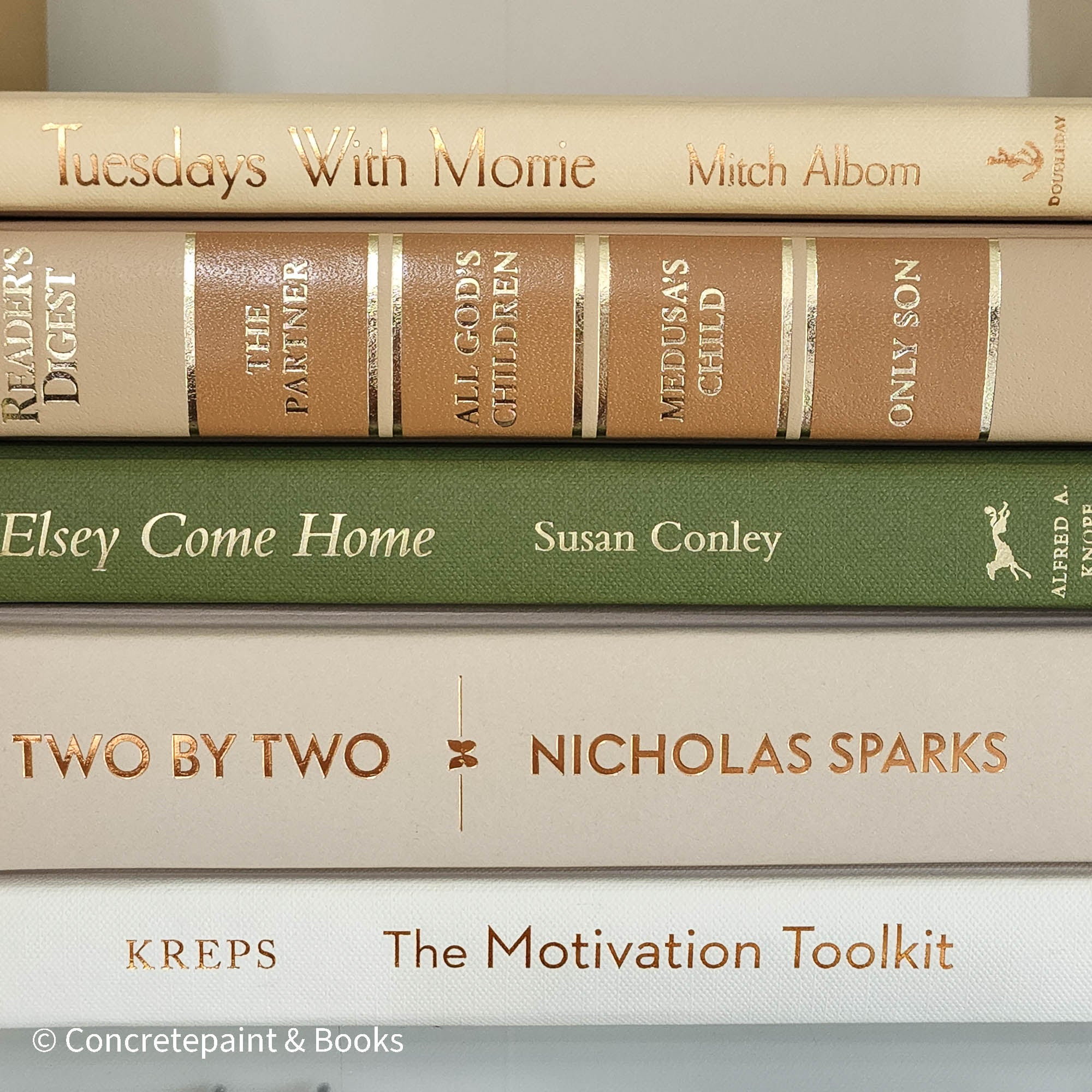 Olive green and neutral books used as shelf decor. Set of books for reading and decorating.