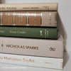 Olive green and neutral books used as shelf decor. Set of books for reading and decorating.