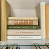 Olive green and neutral books used as shelf decor. Set of books for reading and decorating.