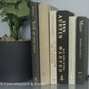 Set of hardcover books in gray and neutral colors staged and used as decorating home display. 