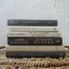 Set of hardcover books in gray and neutral colors staged and used as decorating home display. 
