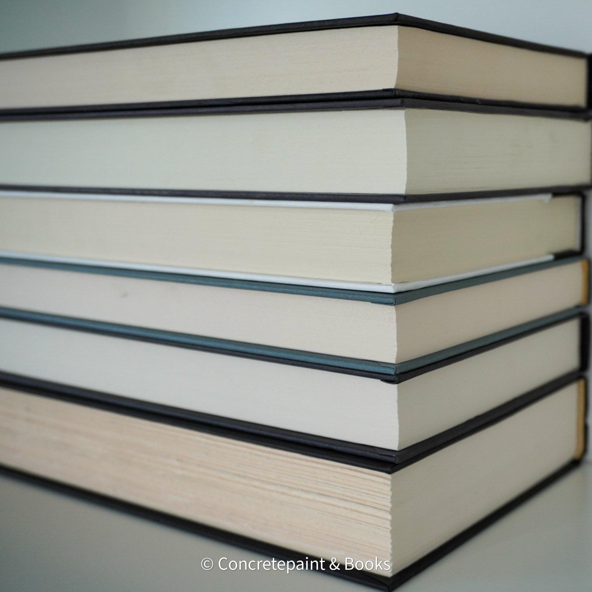 Stack of black and gray hardcover books with copper font. Real books staged and used as shelf décor.