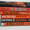 Stack of black and gray hardcover books with copper font. Real books staged and used as shelf décor.