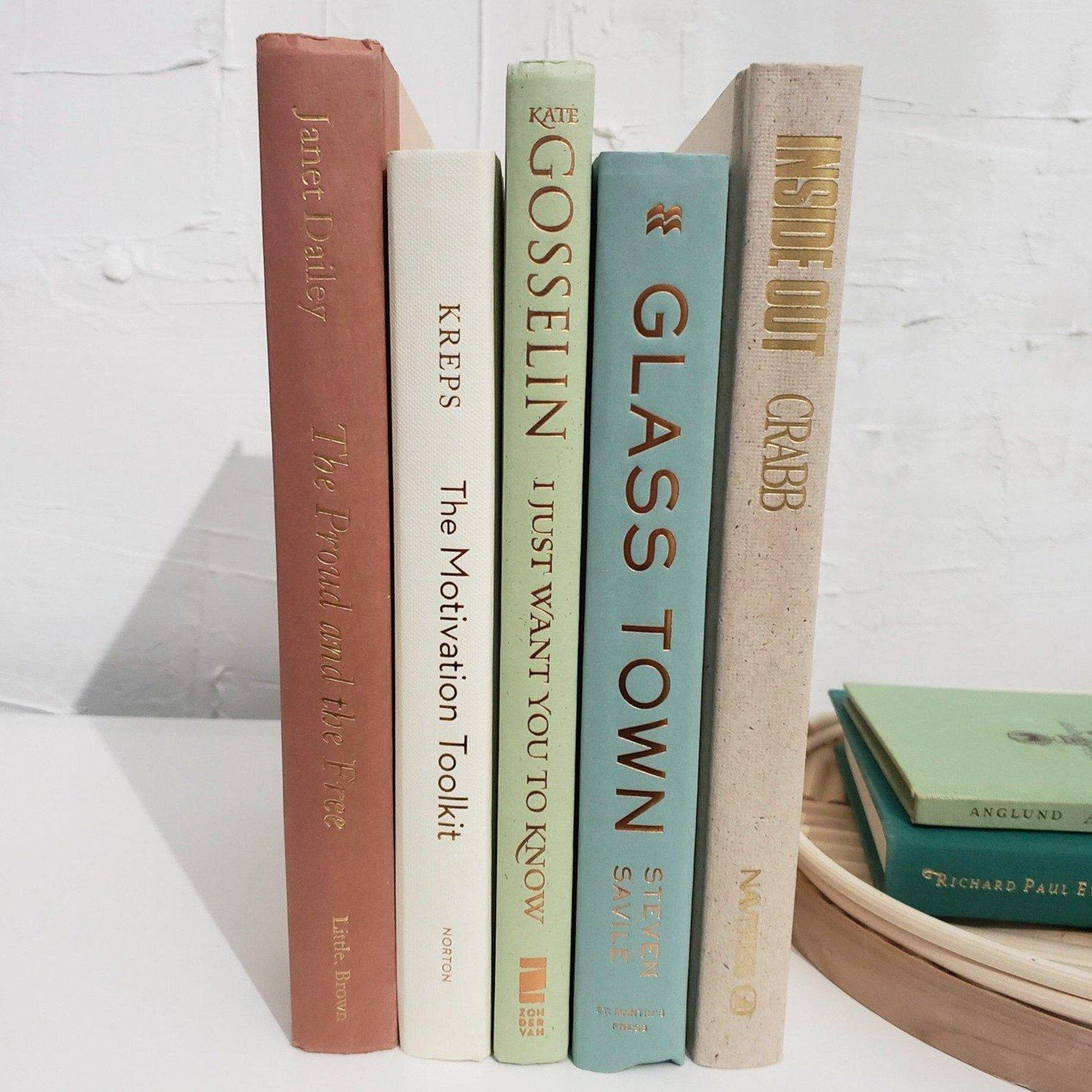 Large set of books with decorative accent tray. Real hardcover books us3d as home decor. Decorative tray with green books on top.