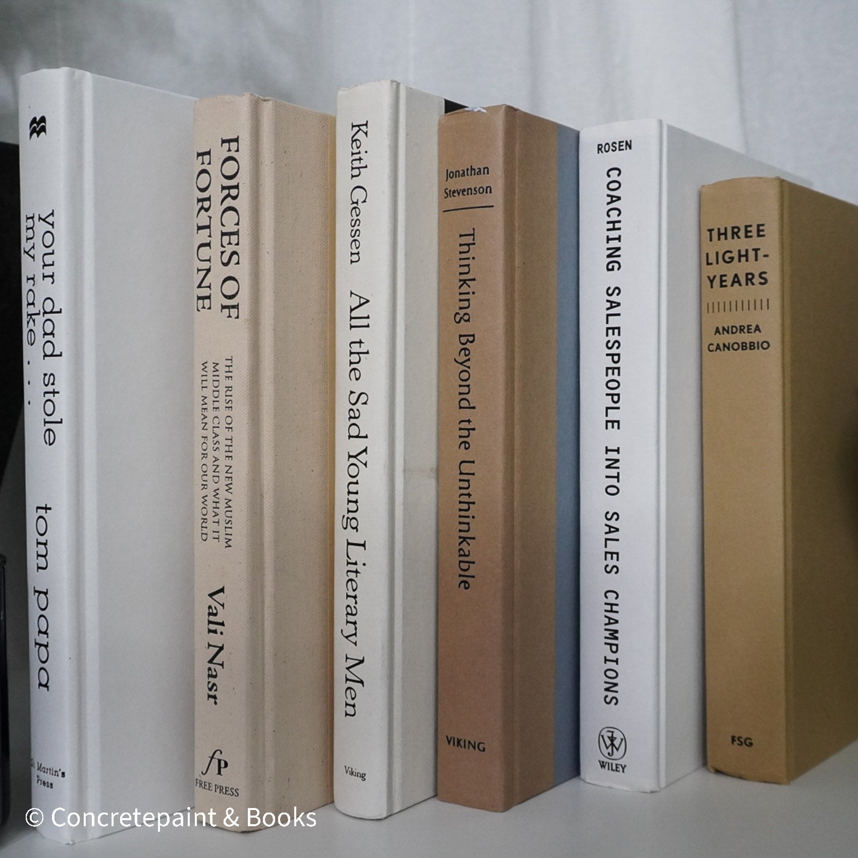 Neutral, sand and white books on display. Real hardcover books for decorating shelves.