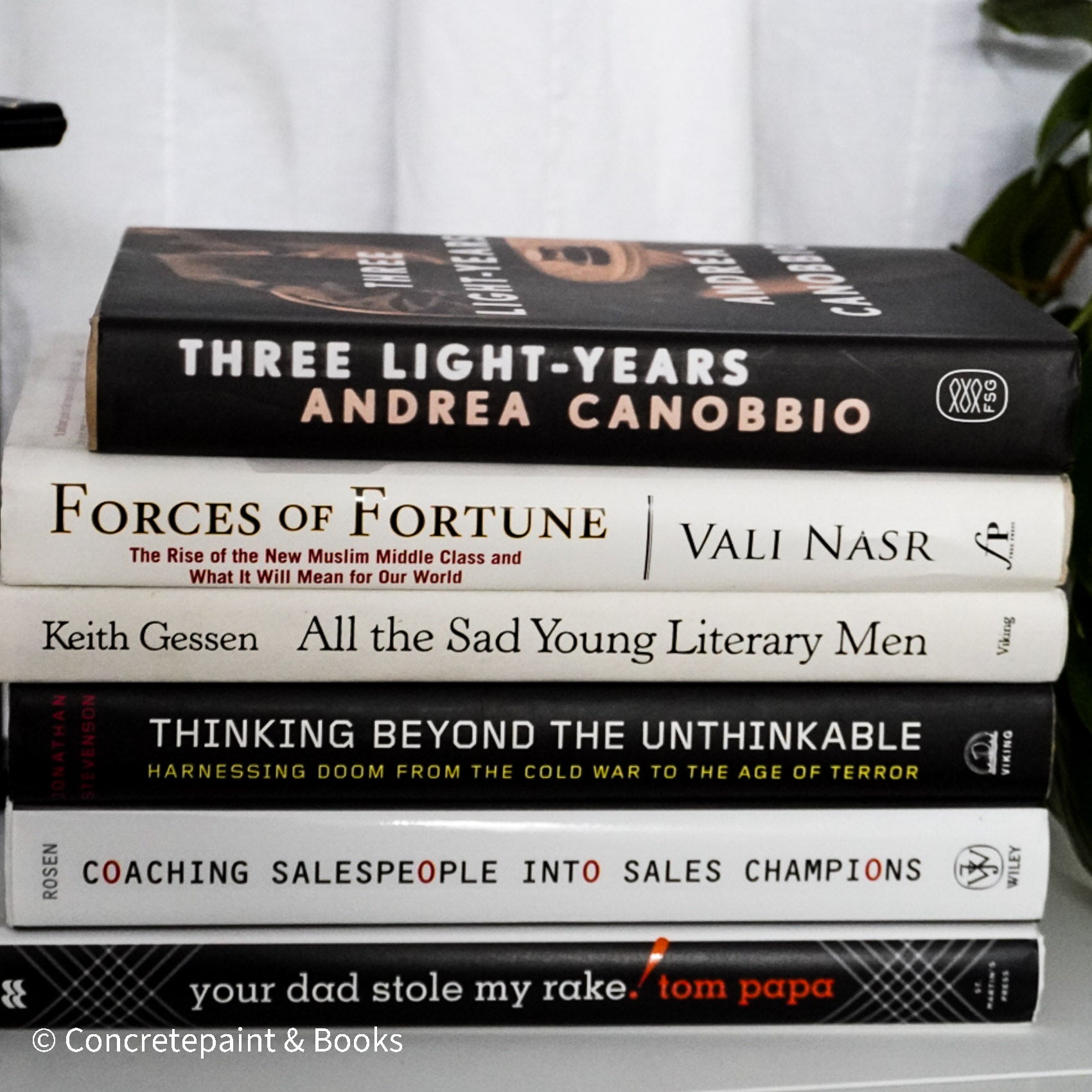 Neutral, sand and white books on display. Real hardcover books for decorating shelves.