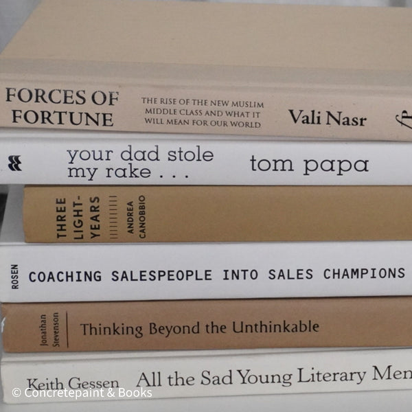 Neutral, sand and white books on display. Real hardcover books for decorating shelves.