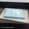 Decorative concrete tray with light blue hardcover book on top. Leading with Love Book and concrete home décor.