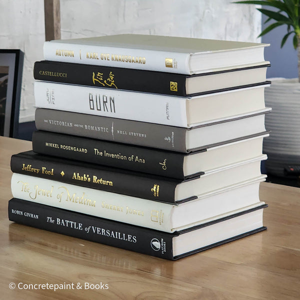 Black gray white and neutral books on display. Stack of decorative books.