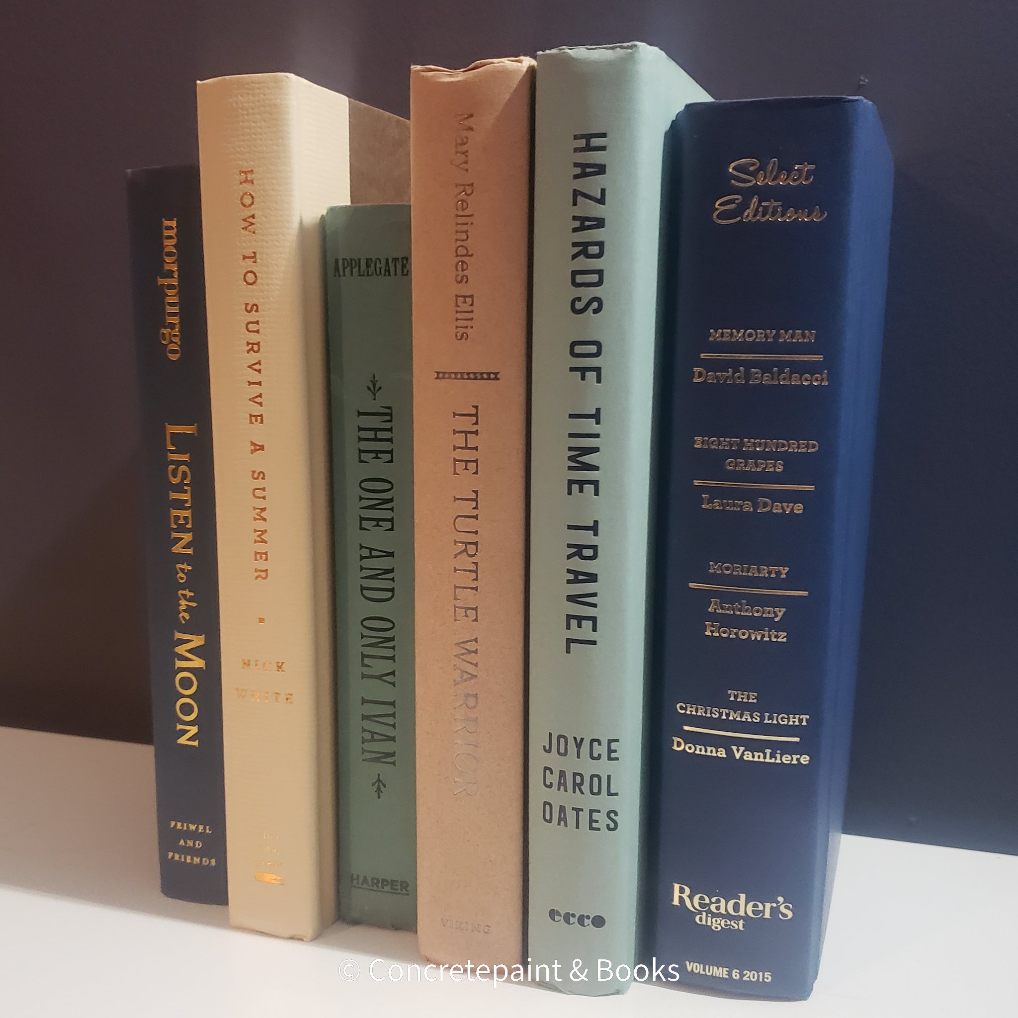 Neutral, mint, and navy color books used for decorating. Stack of real hardcover books for display. 
