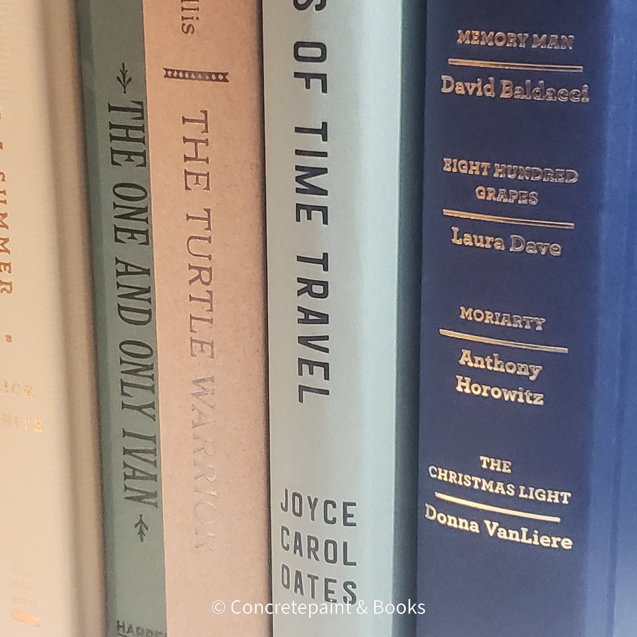 Neutral, mint, and navy color books used for decorating. Stack of real hardcover books for display. 