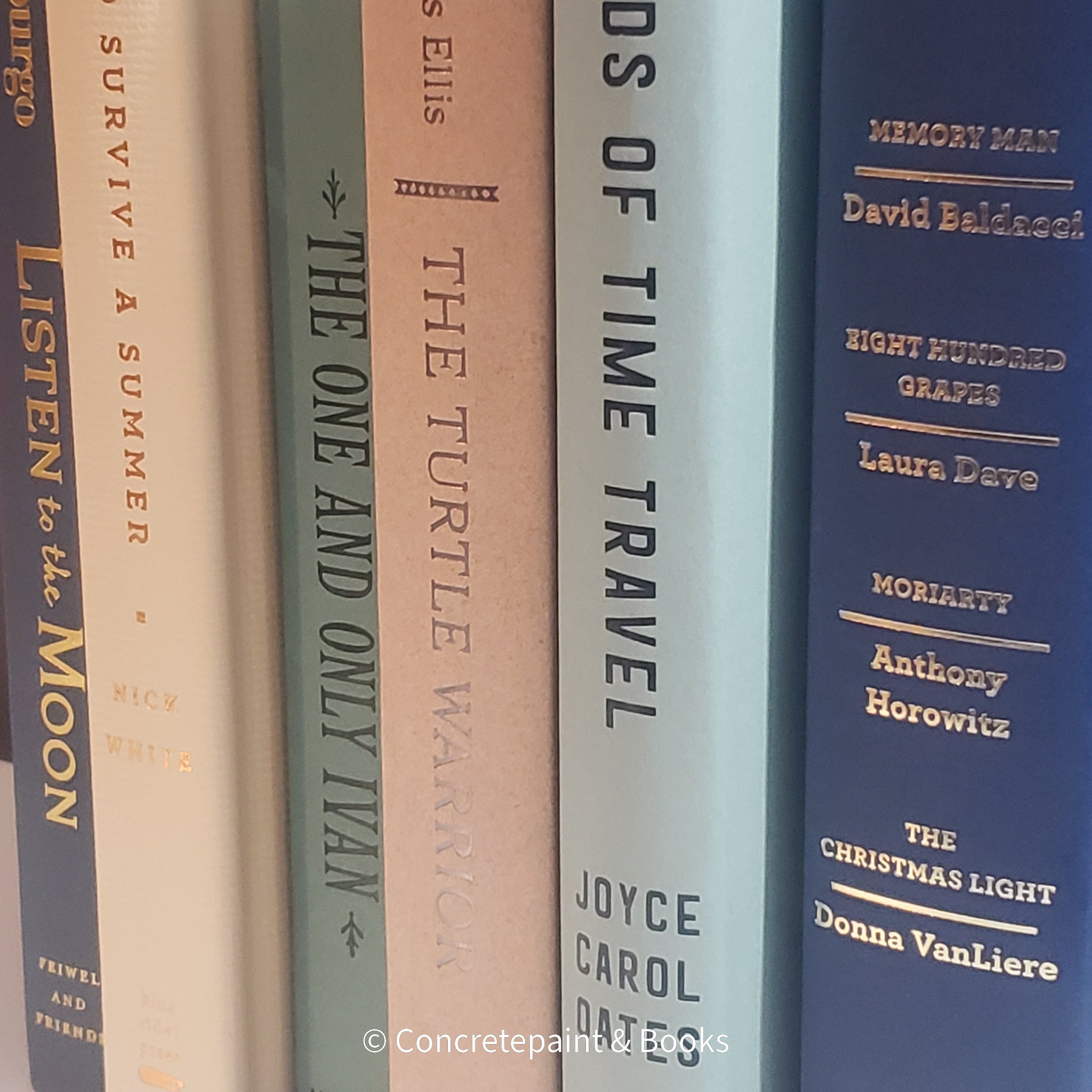 Neutral, mint, and navy color books used for decorating. Stack of real hardcover books for display. 