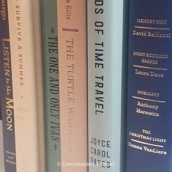 Neutral, mint, and navy color books used for decorating. Stack of real hardcover books for display. 