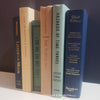 Neutral, mint, and navy color books used for decorating. Stack of real hardcover books for display. 