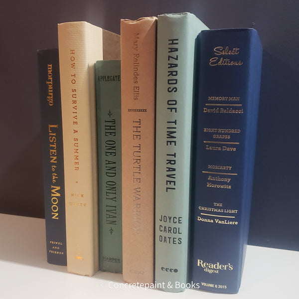Neutral, mint, and navy color books used for decorating. Stack of real hardcover books for display. 