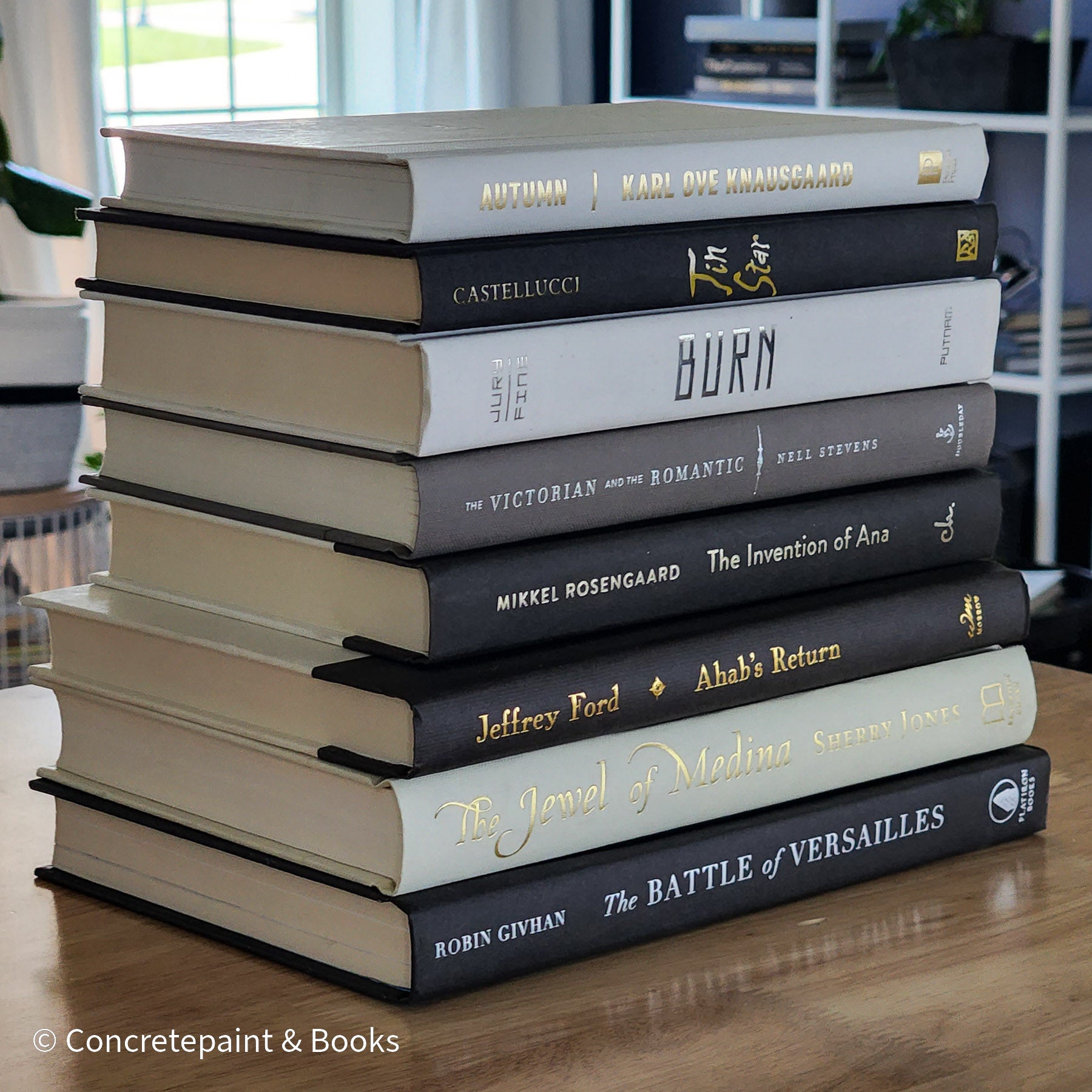 Black gray white and neutral books on display. Stack of decorative books.