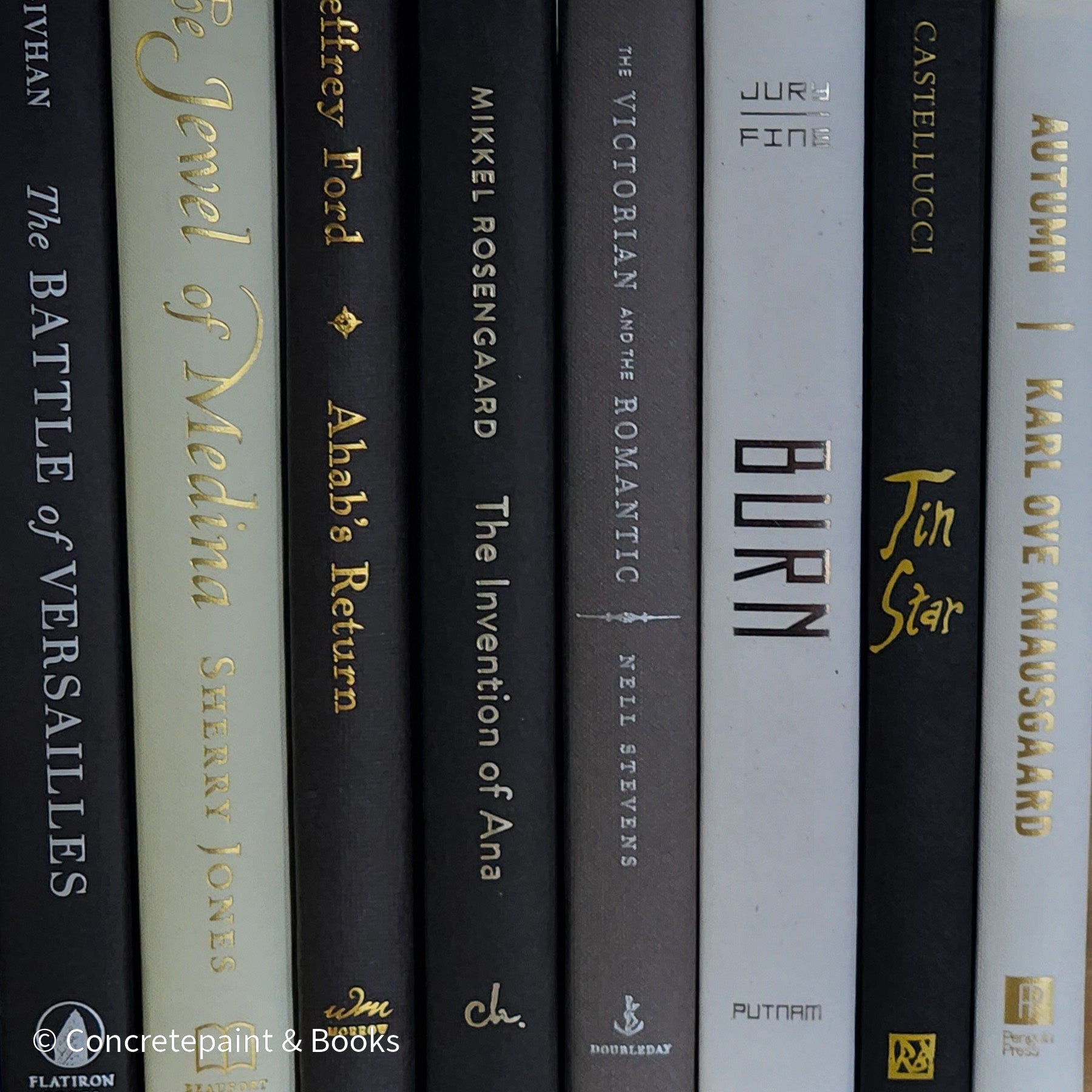 Black gray white and neutral books on display. Stack of decorative books.