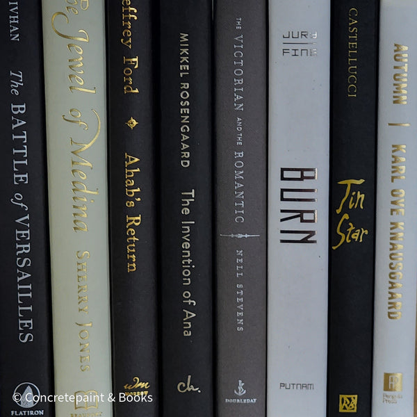 Black gray white and neutral books on display. Stack of decorative books.