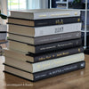 Black gray white and neutral books on display. Stack of decorative books.