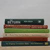 Real books as display on shelf. Hardcover green, neutral, and terra cotta color.