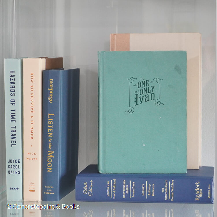 Neutral, mint, and navy color books used for decorating. Stack of real hardcover books for display. 