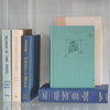 Neutral, mint, and navy color books used for decorating. Stack of real hardcover books for display. 